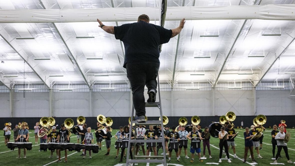 Graduate teaching assistant and doctoral student Drew Bonner conducts Oct. 26 during a Hawkeye Marching Band practice at the Hawkeye Tennis and Recreation Complex in Iowa City. (Nick Rohlman/The Gazette)