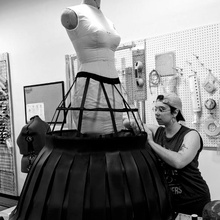 Bella Fortunado adding fabric to a cage crinoline in the costume shop