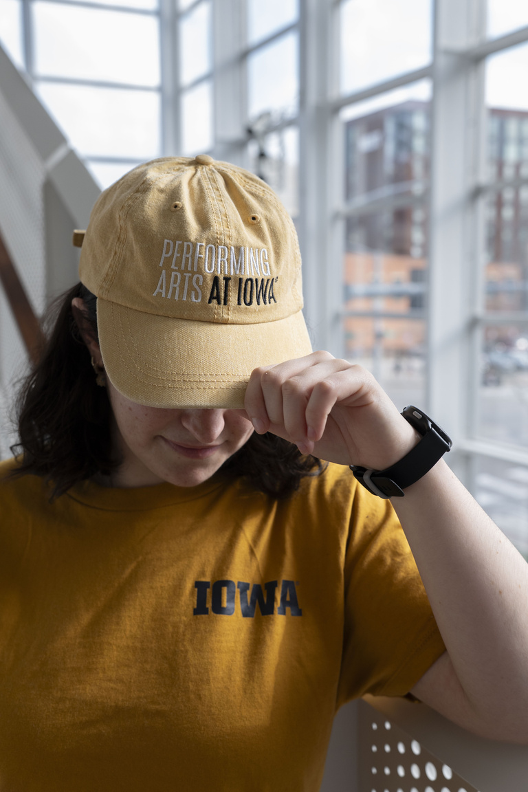 Close up of a student wearing a Performing Arts At Iowa baseball hat