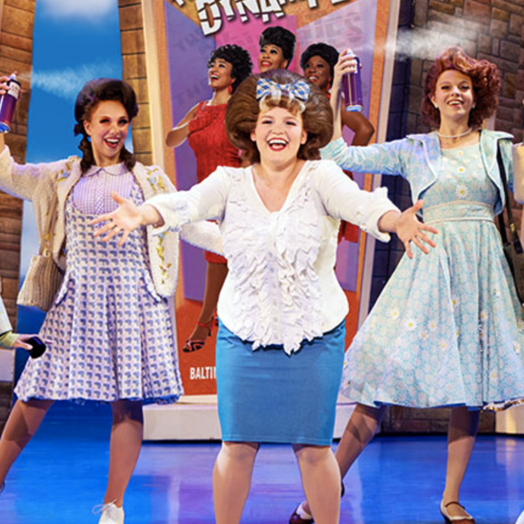 University of Iowa theatre alumna Amy Rodriguez (center, with 2 castmates on each side of her) onstage as Tracy Turnblad in the touring Broadway production of Hairspray