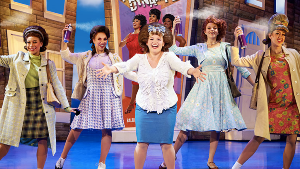University of Iowa theatre alumna Amy Rodriguez (center, with 2 castmates on each side of her) onstage as Tracy Turnblad in the touring Broadway production of Hairspray