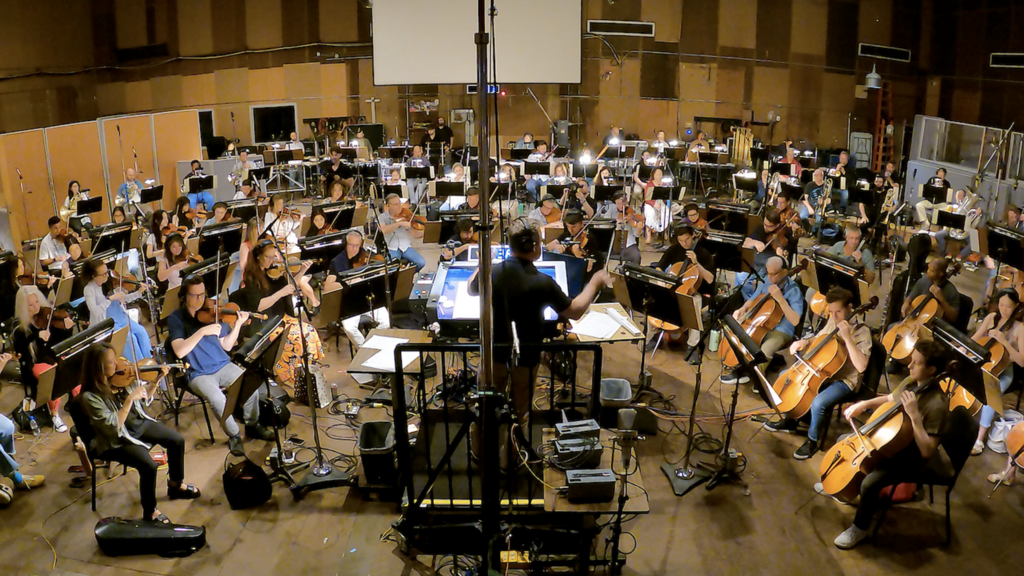 University of Iowa alumnus Scott Icenogle conducts an 85-piece orchestra for the first recording of his original composition Ode to Voxman.